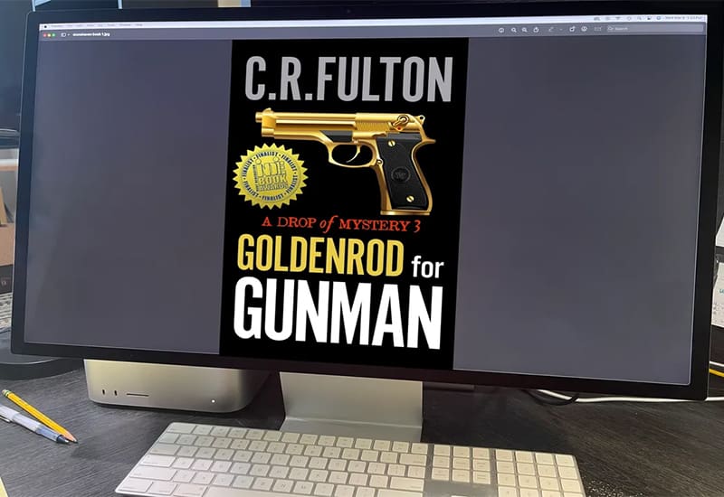 A computer with a book cover on the keyboard