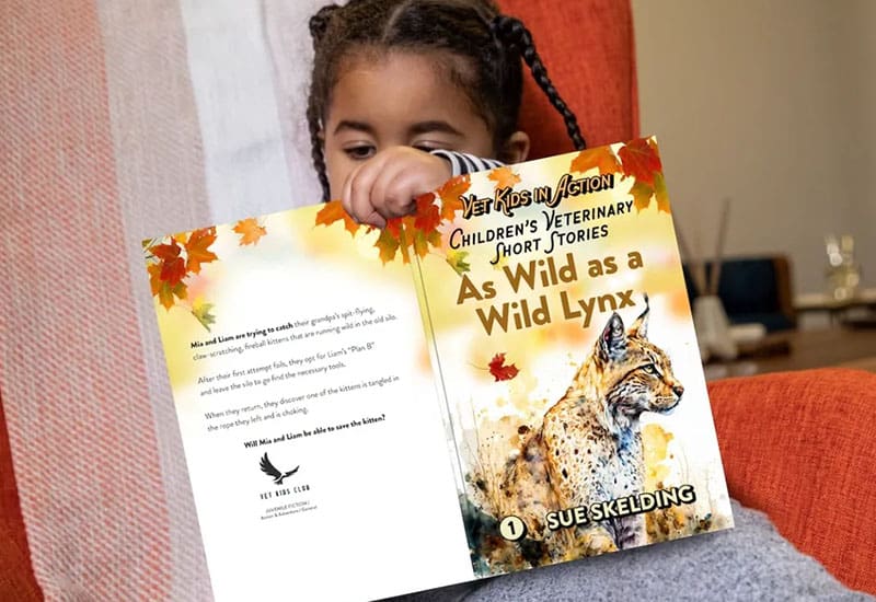 A little girl is reading an animal book.