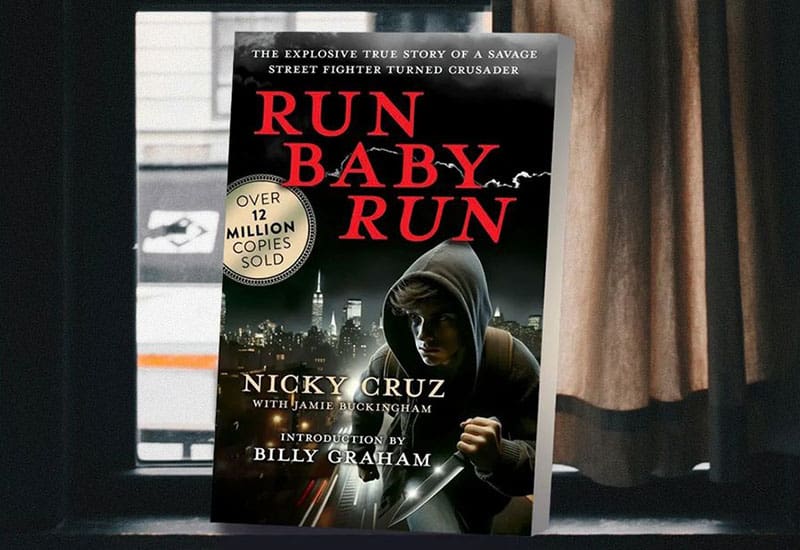 A book cover with a hooded man in the background.