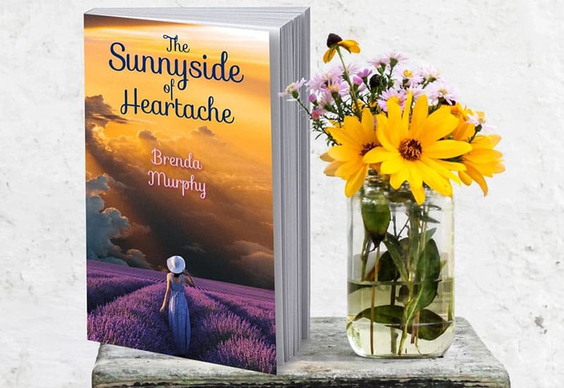 A book sitting next to a vase of flowers.